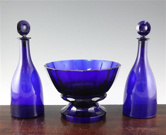 A pair of Bristol blue glass mallet shaped decanters and target stoppers, and a similar panel cut pedestal bowl, first half 19th centur
